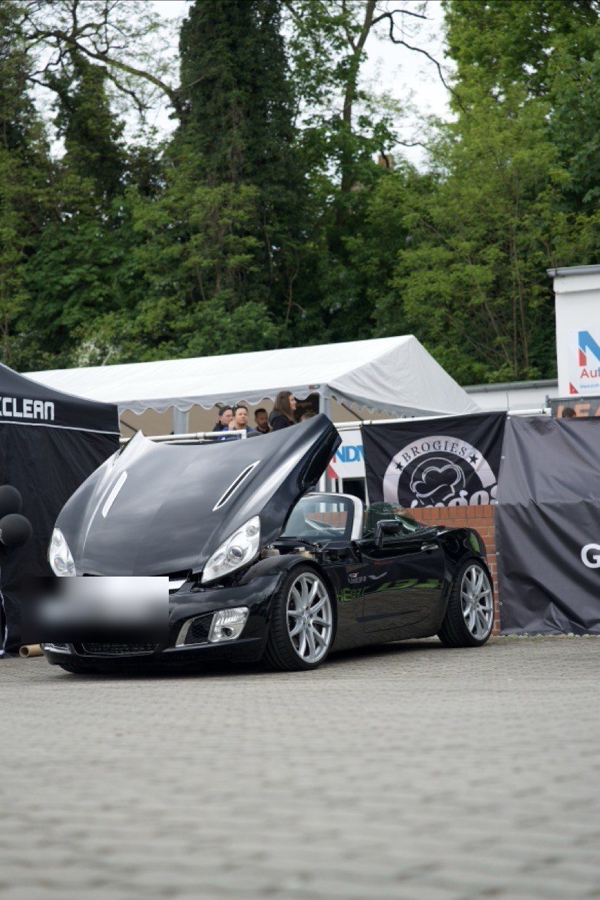 Opel GT mit geöffneter Motorhaube vor C-Clean-Branding